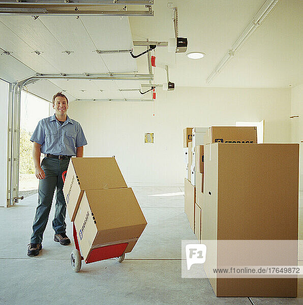 Portrait of man carrying boxes on dolly