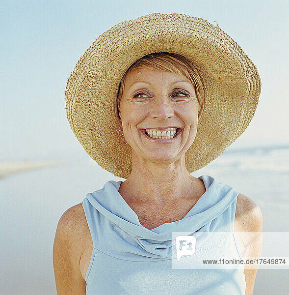 Portrait of mature woman wearing hat on beach