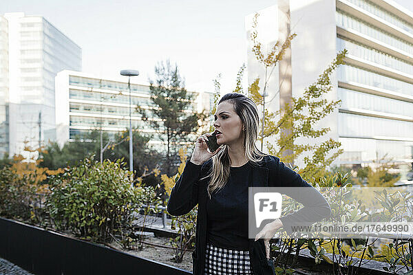 Businesswoman talking on smart phone in city
