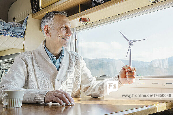 Man holding wind turbine model in camper van