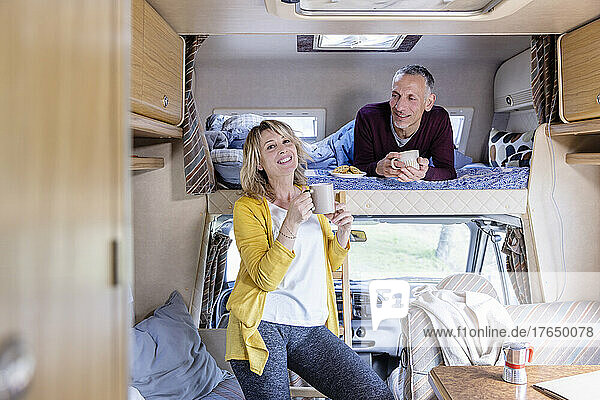 Man looking at woman with coffee cup in motor home