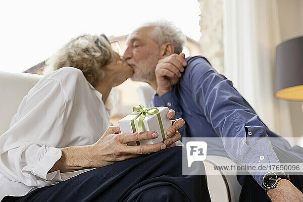 Affectionate senior couple kissing each other in hotel apartment