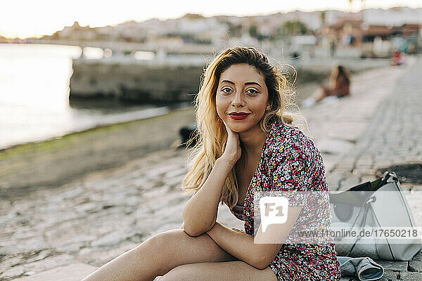 Young woman sitting at seashore