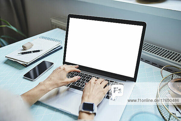 Freelancer typing on laptop working at home
