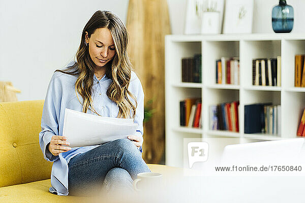 Freelancer with documents doing paperwork at home