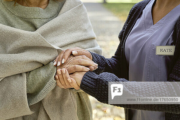 Hausmeister hält Händchen und tröstet ältere Frau