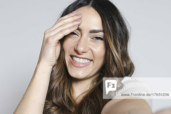 Happy woman with brown hair against white background