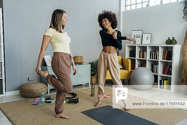 Women doing warm up exercise in living room at home