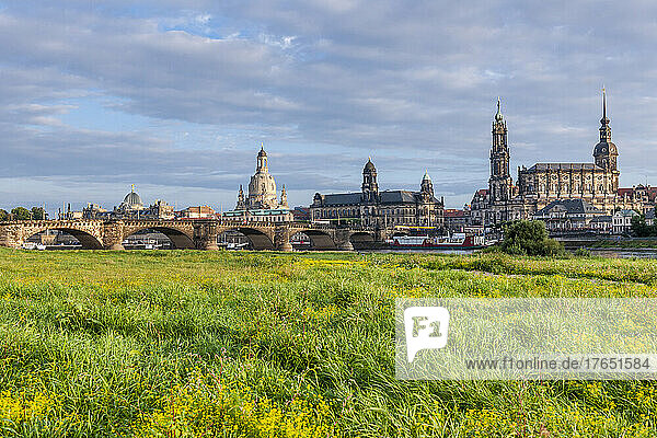 Germany  Saxony  Dresden  Grassy bank of Elbe river with Augustus Bridge and old town buildings in background