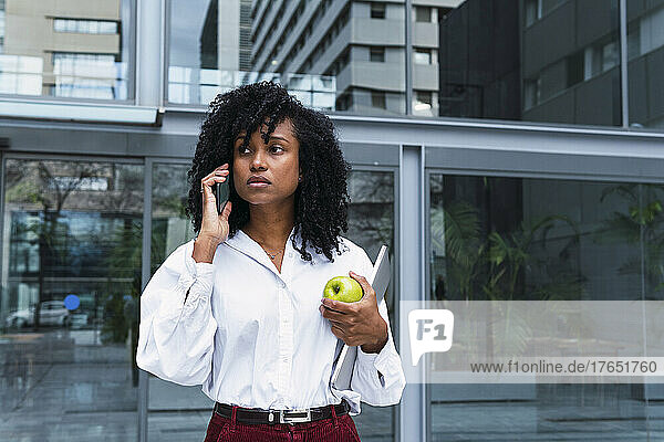Businesswoman talking on mobile phone at office park