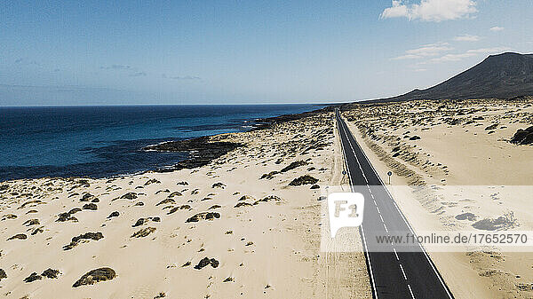 Spanien  Fuerteventura  Luftaufnahme einer Autobahn  die sich durch die sandige Landschaft des Naturparks Corralejo erstreckt