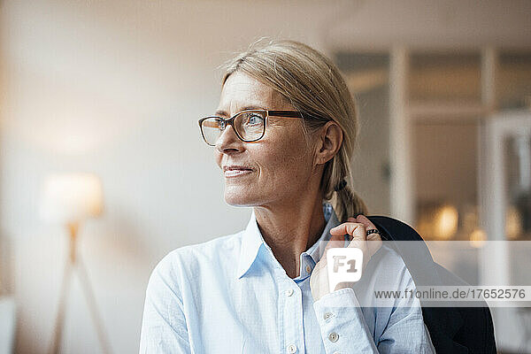 Contemplative businesswoman with blazer at work place