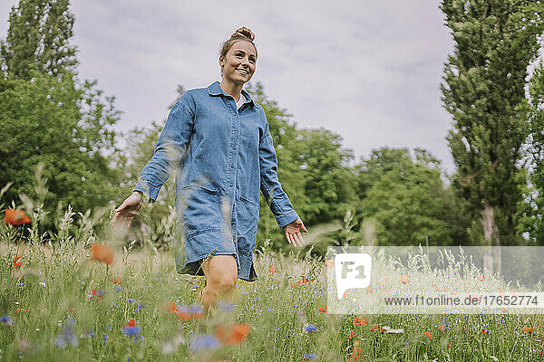 Young woman enjoying walking in meadow