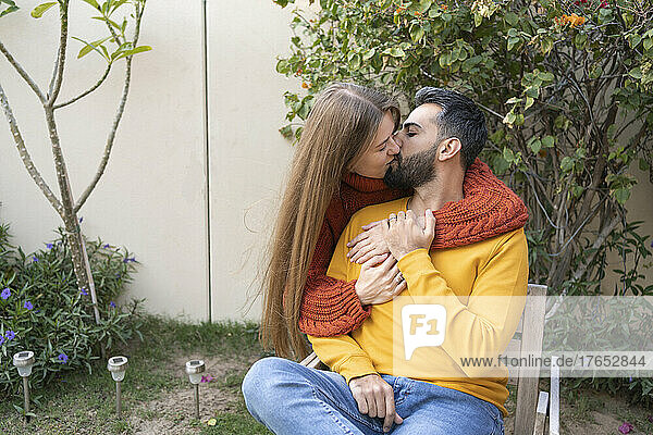 Affectionate loving couple kissing in back yard garden