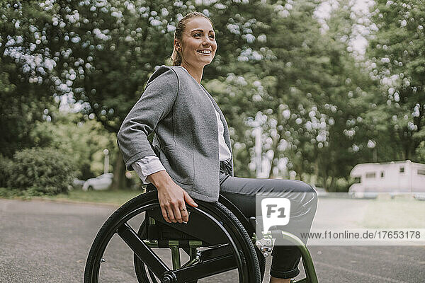 Happy young businesswoman sitting in wheelchair