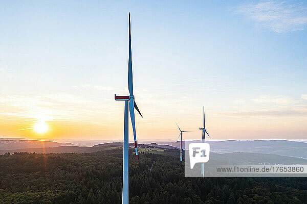Germany  Baden-Wurttemberg  Aerial view of wind farm turbines in Schurwald range at sunset