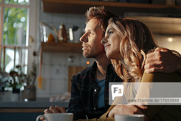 Couple sitting together in kitchen at home