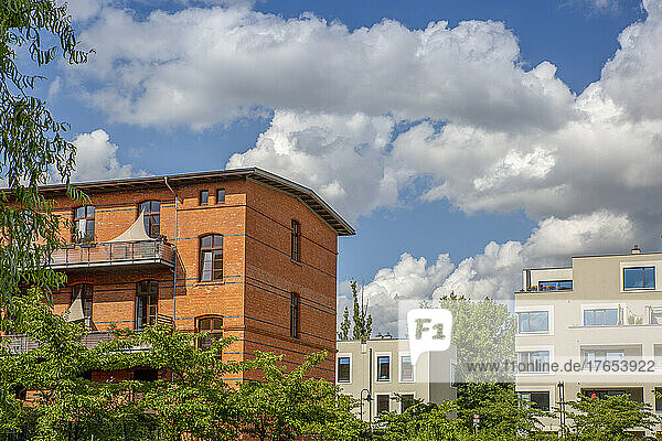 Deutschland  Berlin  Wolken über modernen Mehrfamilienhäusern im Neubaugebiet