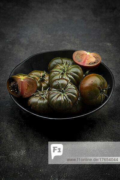 Studio shot of bowl of dark cabomar tomatoes