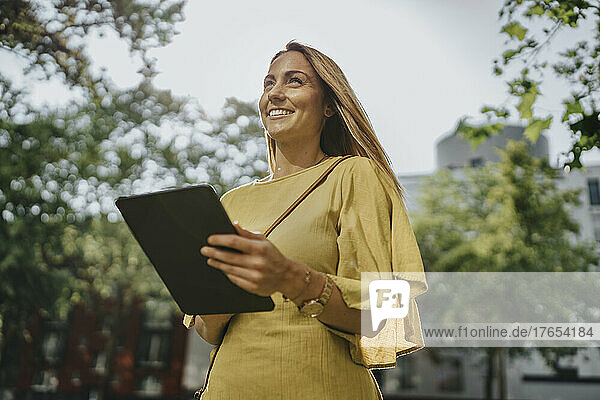 Happy woman with tablet PC on sunny day