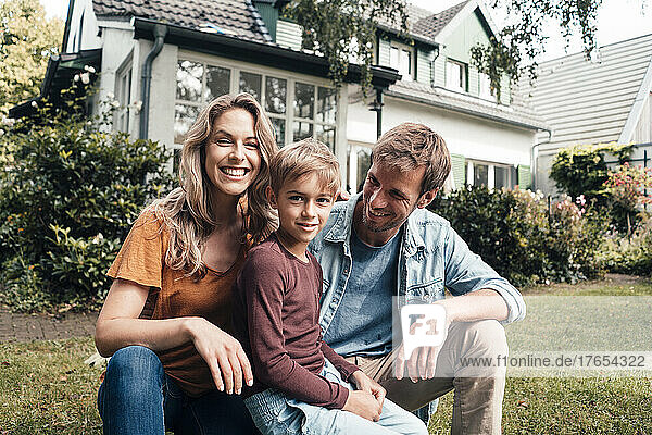 Smiling blond woman with man and son at backyard