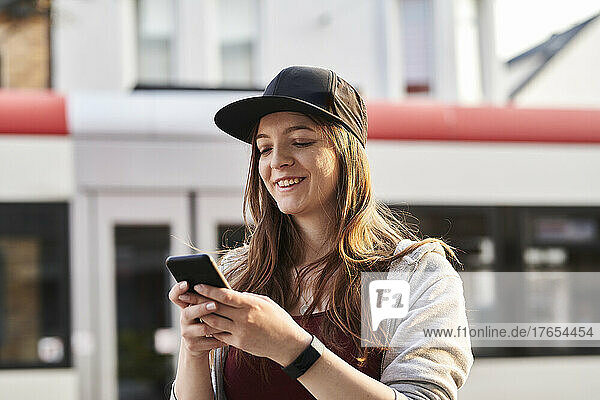 Junge Frau benutzt Smartphone in der Stadt