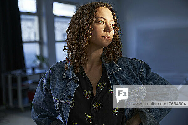 Thoughtful woman with curly hair looking away