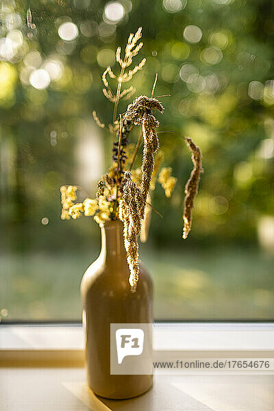Flower vase on window sill at home