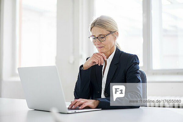 Businesswoman working on laptop at work place