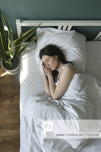 Woman sleeping in bedroom at home