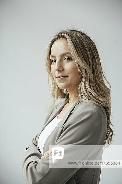 Businesswoman with arms crossed against white background