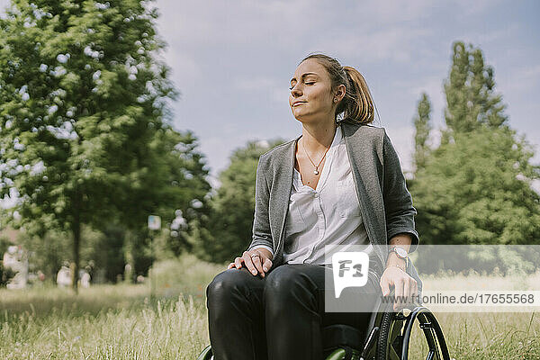 Disabled woman with eyes closed in park