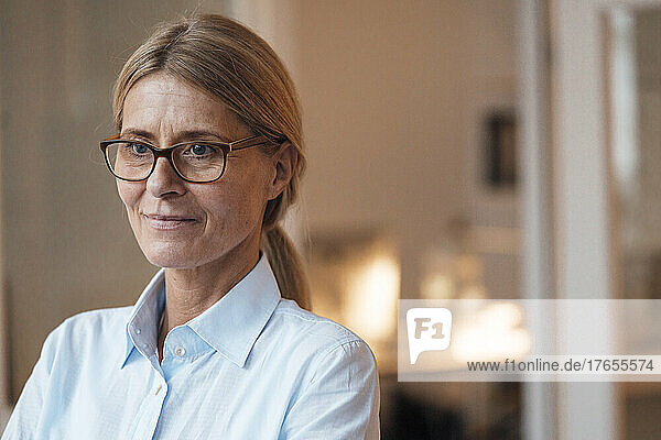 Thoughtful businesswoman with eyeglasses at work place