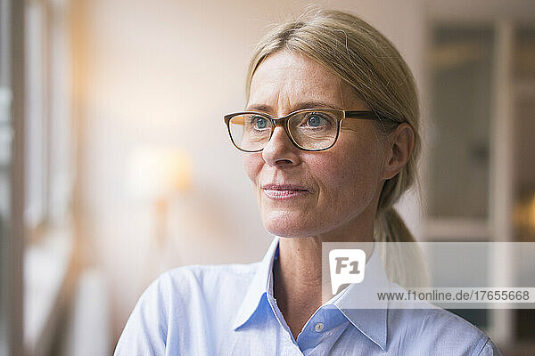 Contemplative businesswoman with eyeglasses at work place