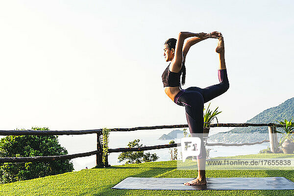 Thai woman doing morning yoga exercise at her home terrace