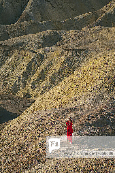 Female walking in a red dress in Death Valley at Zabriskie Point