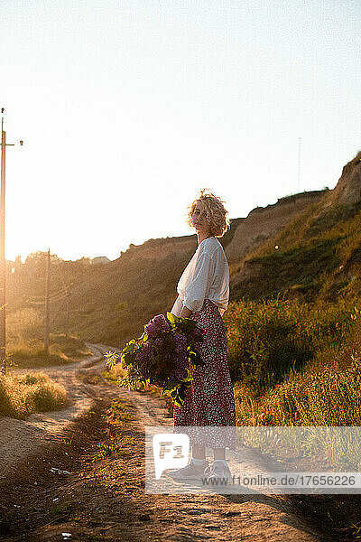 woman blonde in white blouse on sunset with blowers