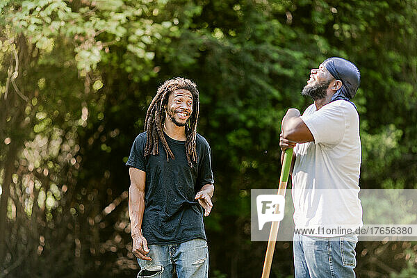 Two black farmers smiling and laughing with each other outside