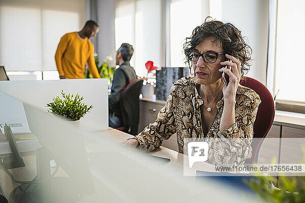 Senior woman talking on the phone working in an office.