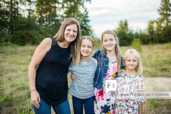 Outdoor portrait of mother and her three beautiful daughters.