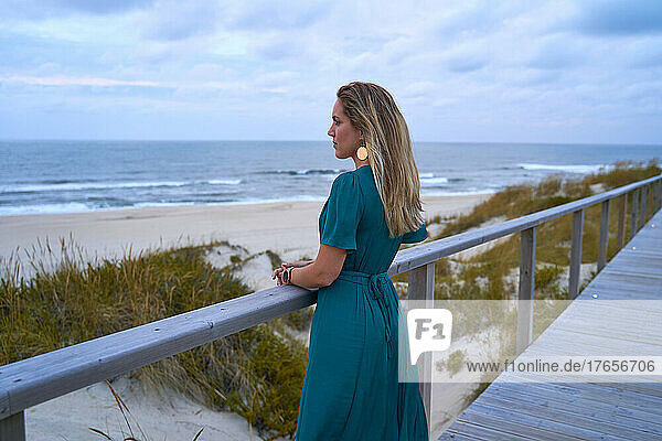 beautiful and elegant girl looking pensively at the sea