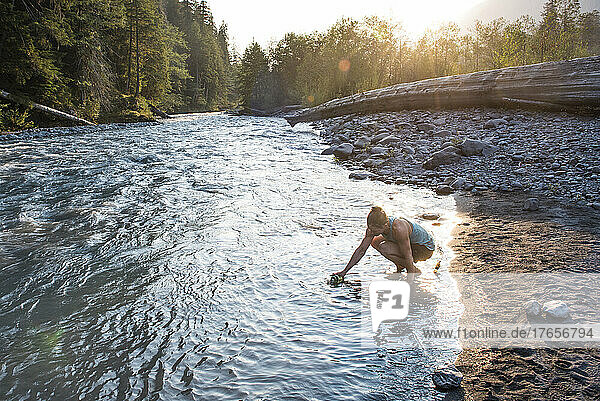 A woman fills a water bottle from the Hoh River.