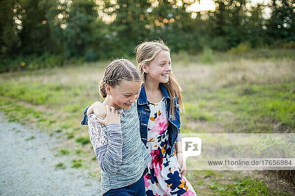 Two joyful girls laugh  smile  play outside.