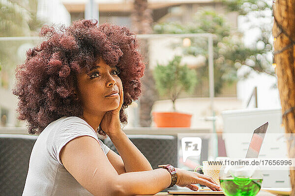 Young Afro woman in a coffee shop working online