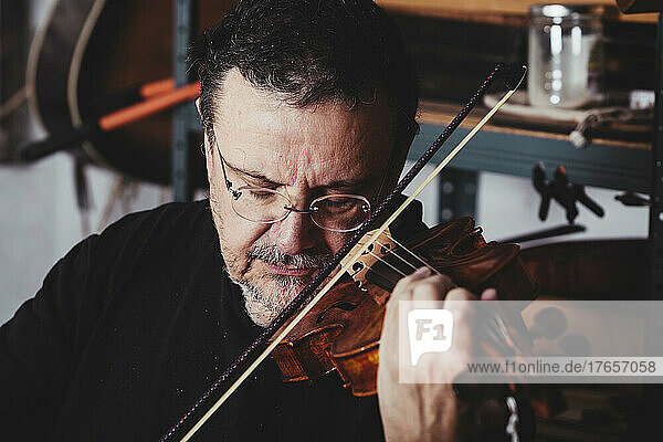 Luthier examining the sound of a varnished violin