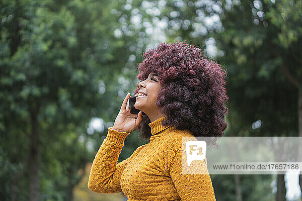 Young Afro woman on a phone call with her cell phone outdoors.