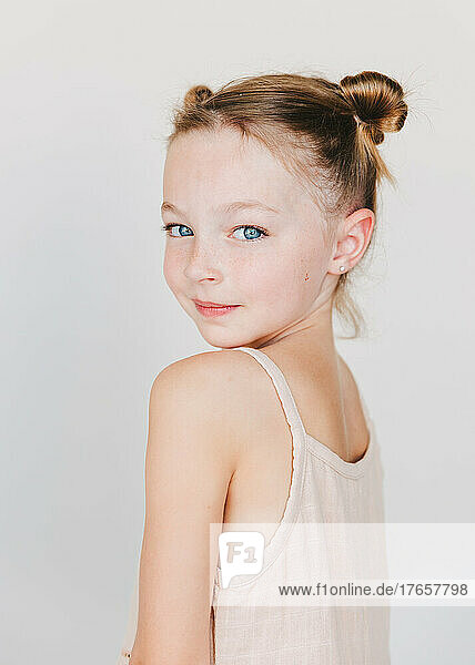 cute little girl looking over her shoulder  white background