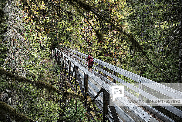 Woman crossing a bridge on the Hoh River trail