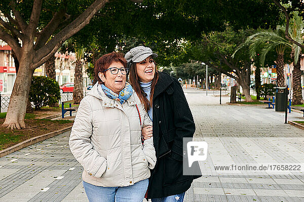 Two women  young and mature  smile and have fun in the street