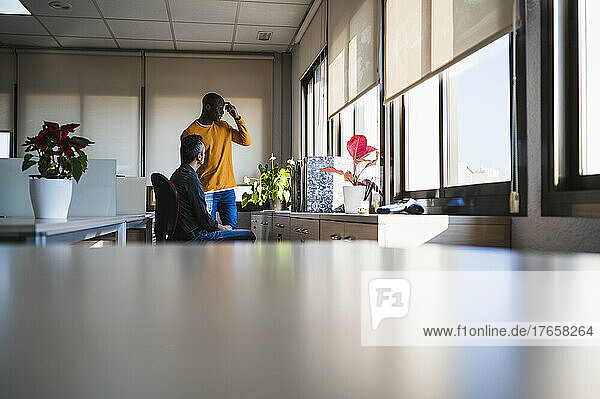 Wide angle view of black and caucasian men working in an office.